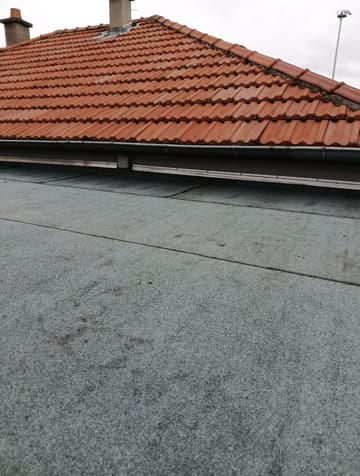 Toit terrasse d'une maison à l'étanchéité neuve, toiture tuiles en arrière-plan