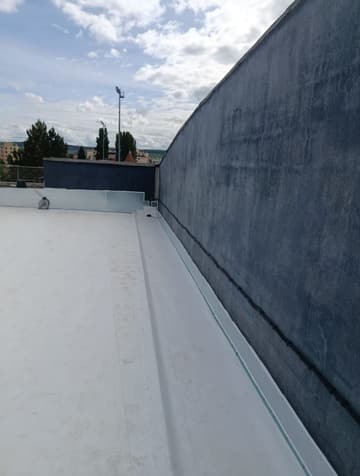 Membrane PVC claire relevée contre un acrotère, toiture terminée