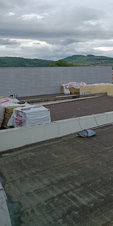 Avant travaux : toiture terrasse à l'ancienne étanchéité grise, matériaux en attente