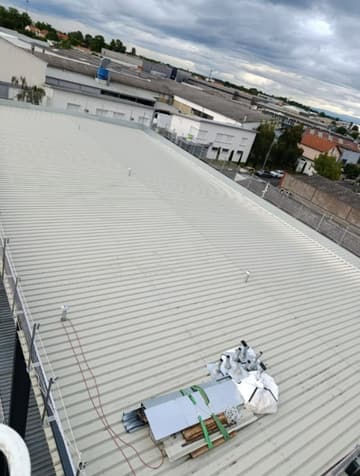 Grande toiture de bâtiment d'activité en membrane PVC grise, équipements techniques
